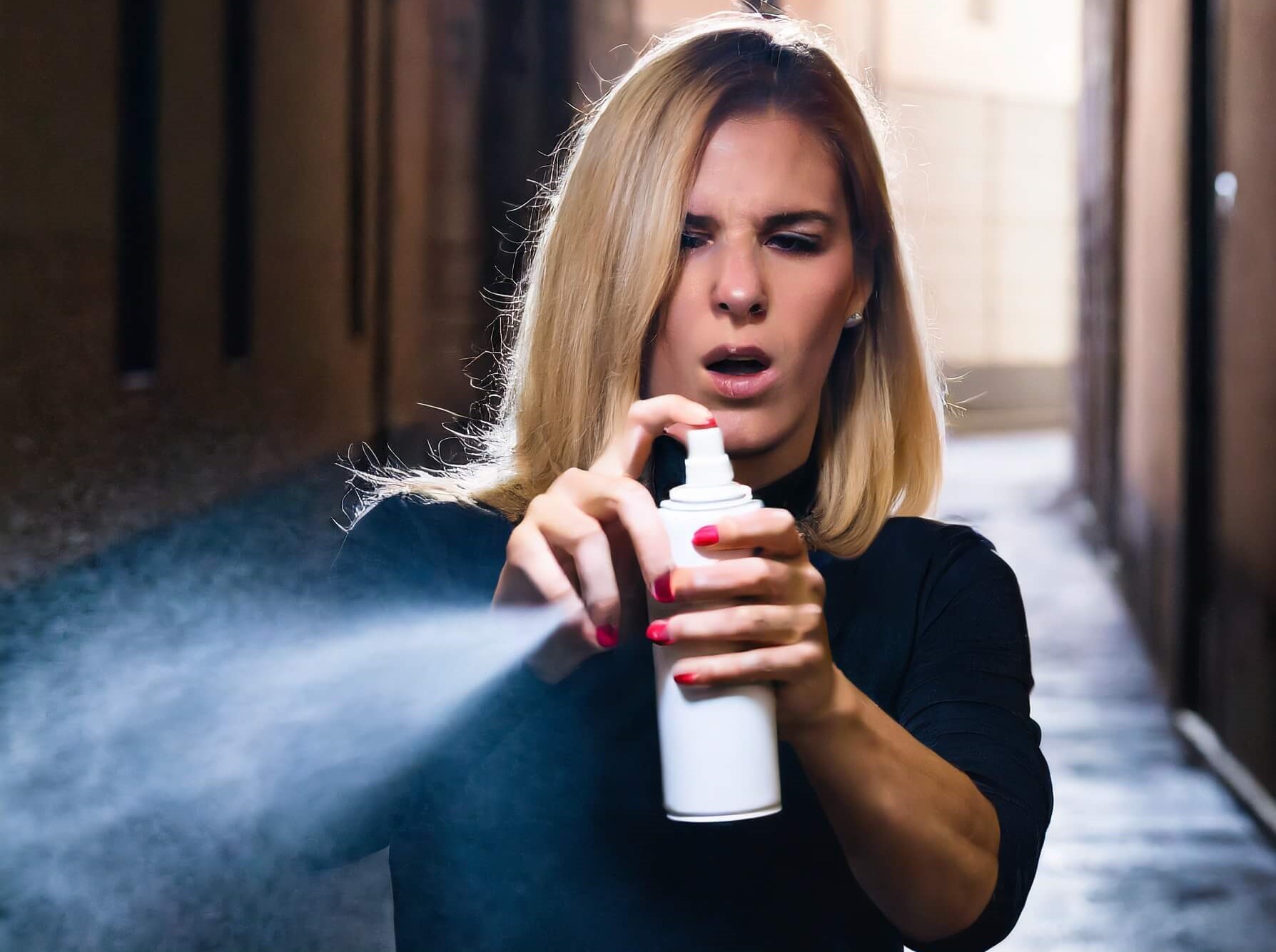 Femme qui utilise une bombe lacrymogène